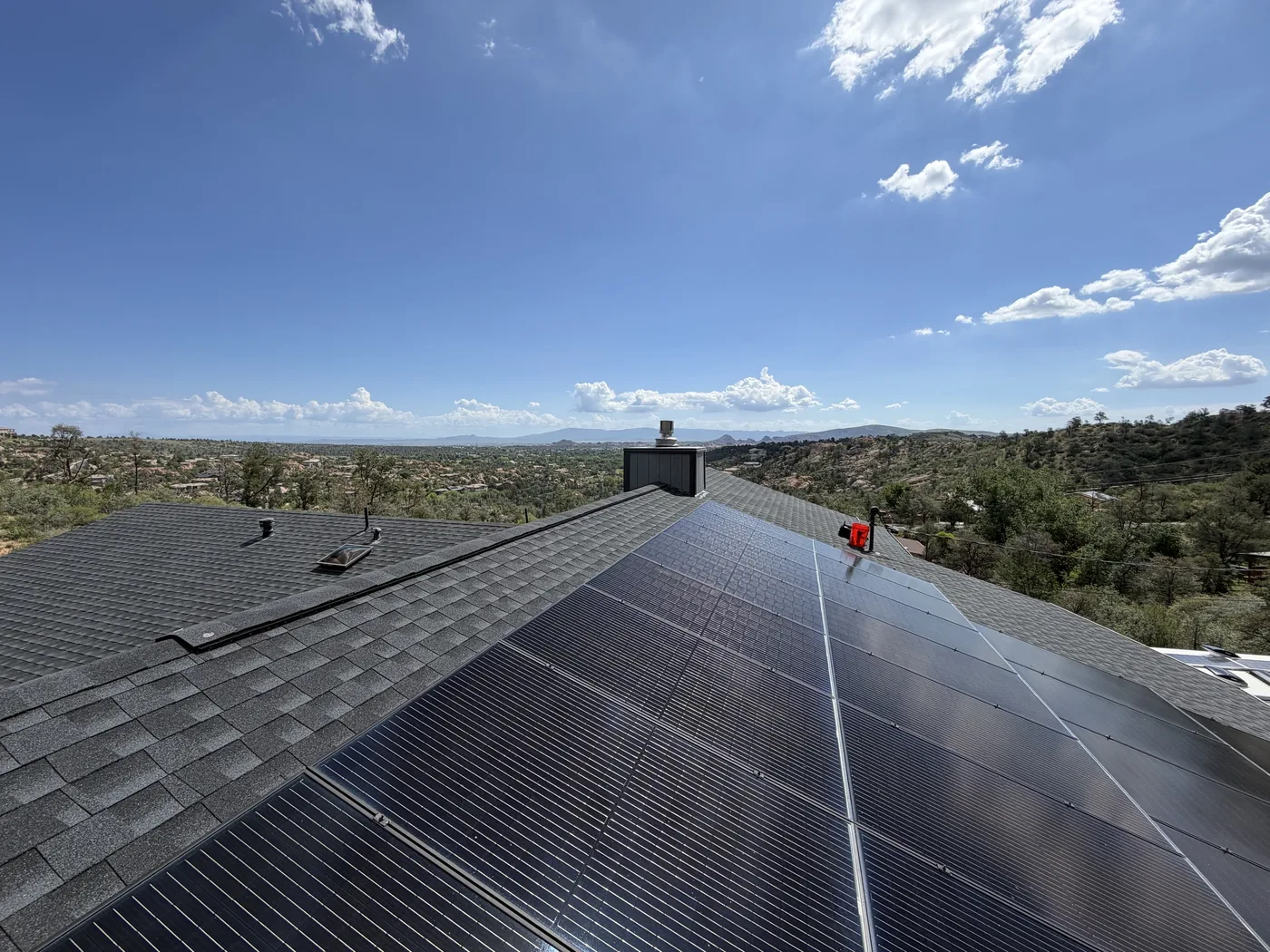 Solar panels installed across a roof overlooking Northern Arizona